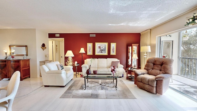 living room with light hardwood / wood-style floors and a textured ceiling