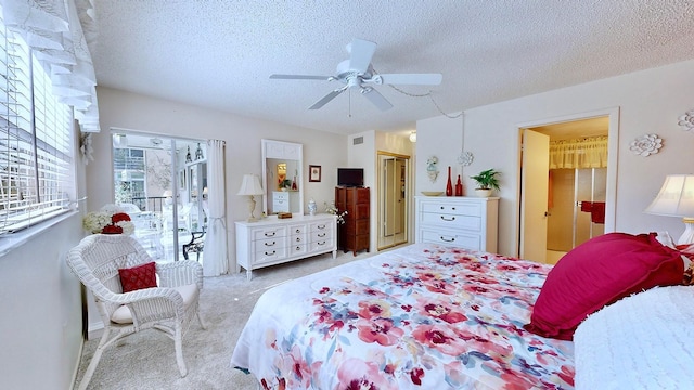 carpeted bedroom featuring ceiling fan, ensuite bath, a textured ceiling, and access to exterior