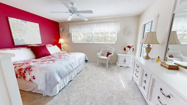 bedroom with light carpet, multiple windows, and a textured ceiling