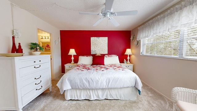 carpeted bedroom featuring ceiling fan and a textured ceiling