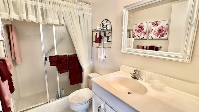 bathroom featuring vanity, toilet, and a shower with door