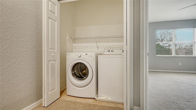 washroom with light carpet, laundry area, independent washer and dryer, and a textured wall