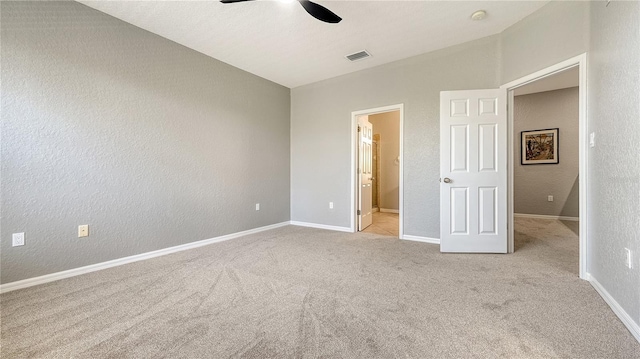 unfurnished bedroom with a textured wall, carpet, and visible vents