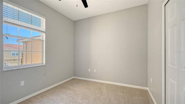 empty room with ceiling fan, carpet floors, and baseboards