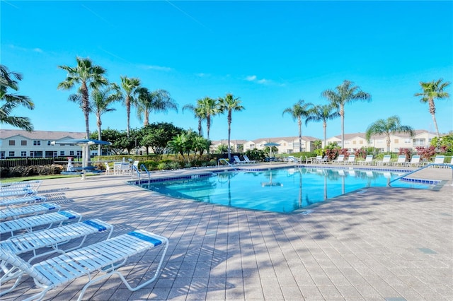 pool with a patio area and a residential view