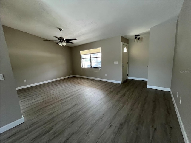 unfurnished living room with dark wood-type flooring and ceiling fan