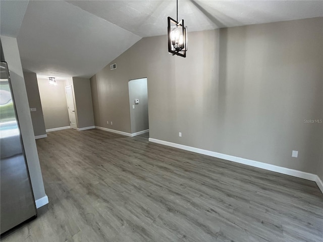 interior space featuring wood-type flooring, lofted ceiling, and an inviting chandelier