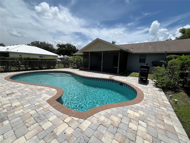 view of swimming pool featuring a patio and a sunroom