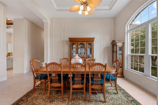 dining area featuring a raised ceiling, a wealth of natural light, crown molding, and light tile patterned floors