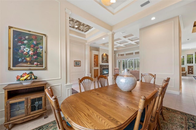 dining room with coffered ceiling, ornate columns, a fireplace, and plenty of natural light