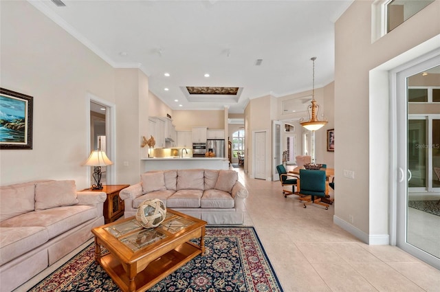 living room with light tile patterned flooring, sink, and ornamental molding