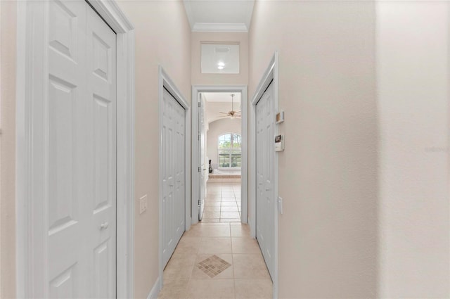 hall featuring crown molding and light tile patterned flooring