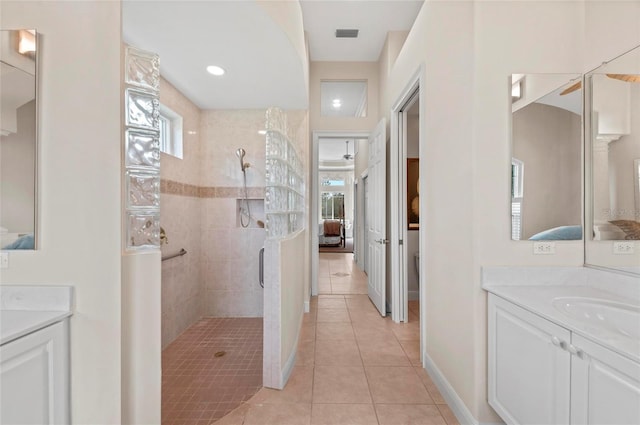 bathroom featuring tile patterned floors, a tile shower, and vanity