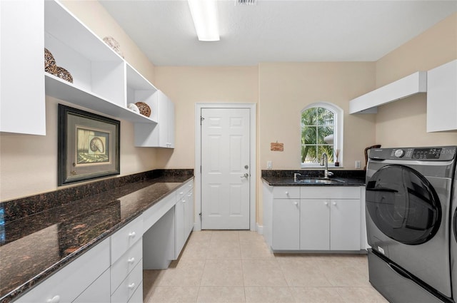 laundry area with light tile patterned floors, sink, cabinets, and washer / dryer