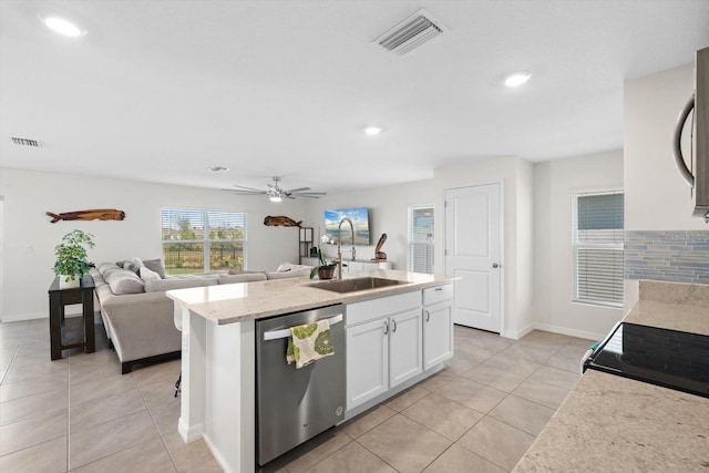 kitchen with white cabinetry, sink, a kitchen island with sink, stainless steel dishwasher, and light tile patterned floors