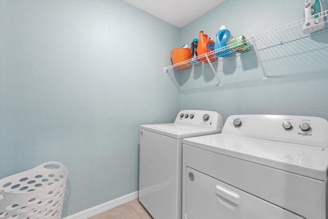 clothes washing area with washer and clothes dryer and light tile patterned floors