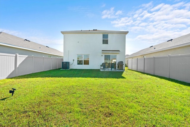 back of house featuring a lawn, central air condition unit, and a patio area