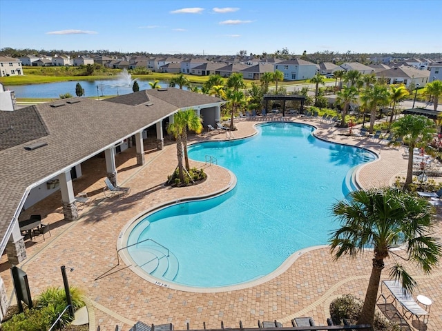 view of swimming pool featuring a water view, a patio area, and a pergola