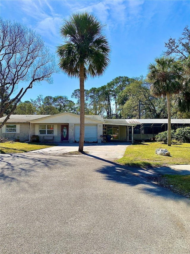 view of front of property featuring a garage, a front lawn, and a carport