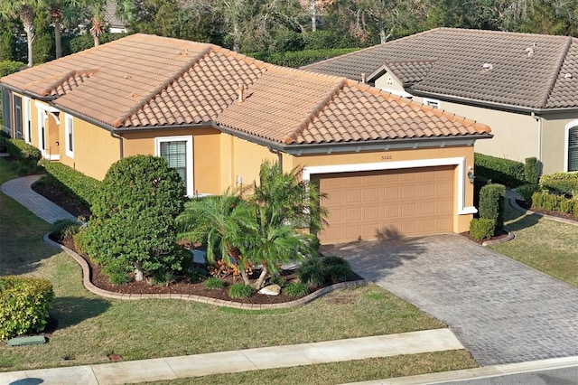 mediterranean / spanish-style home featuring a garage and a front lawn