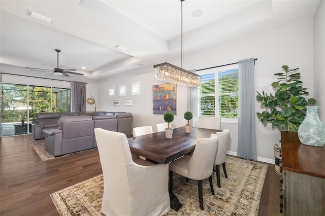 dining room featuring dark hardwood / wood-style floors, ceiling fan, and a tray ceiling