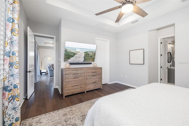 bedroom with ceiling fan, dark hardwood / wood-style floors, and a raised ceiling