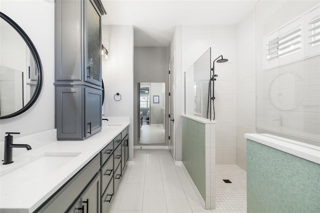 bathroom with tiled shower and vanity