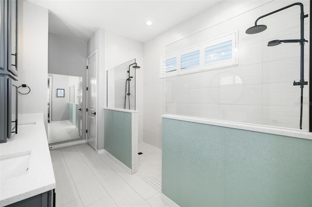 bathroom featuring tiled shower, vanity, and tile patterned floors