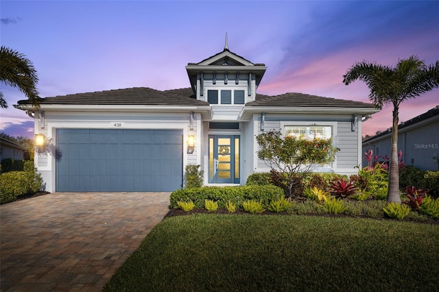 view of front of home with a garage and a yard