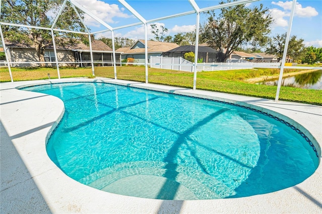 view of swimming pool featuring glass enclosure and a lawn