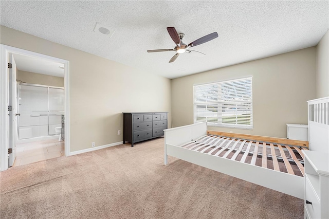 unfurnished bedroom featuring ceiling fan, light colored carpet, a textured ceiling, and ensuite bathroom