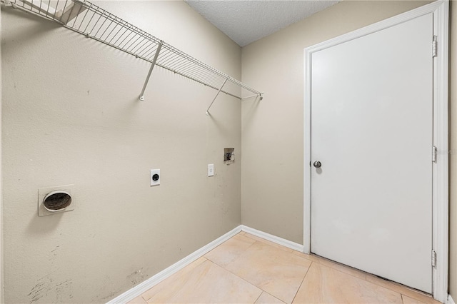 laundry area with hookup for a washing machine, electric dryer hookup, tile patterned floors, and a textured ceiling