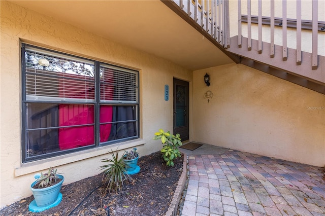 doorway to property featuring a patio area and stucco siding