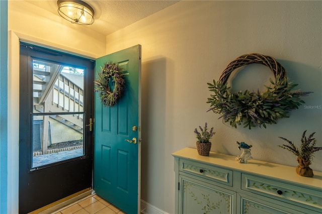 entryway featuring light tile patterned floors and a textured ceiling