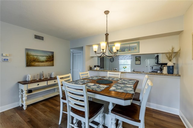 dining area with a notable chandelier, wood finished floors, visible vents, and baseboards