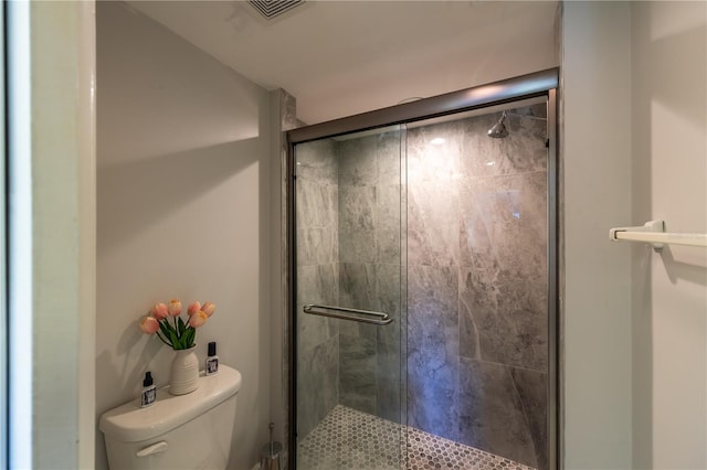 bathroom with visible vents, a shower stall, and toilet