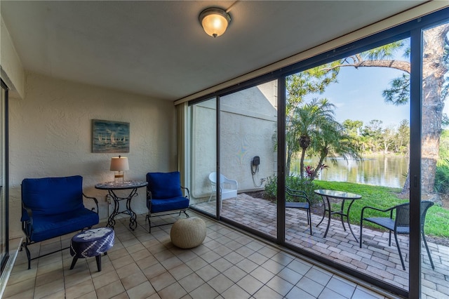 sunroom featuring a water view