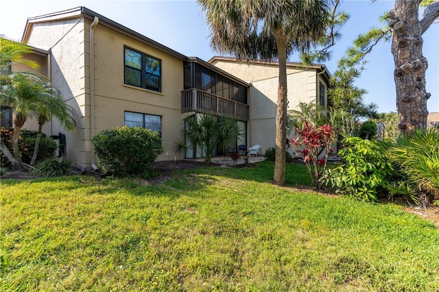 rear view of house with a yard and stucco siding