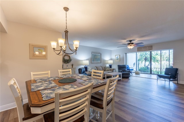 dining space featuring baseboards, wood finished floors, and ceiling fan with notable chandelier