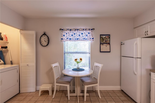 dining room with light tile patterned flooring, washer / dryer, and baseboards