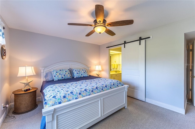 bedroom featuring a barn door, baseboards, light colored carpet, and a ceiling fan