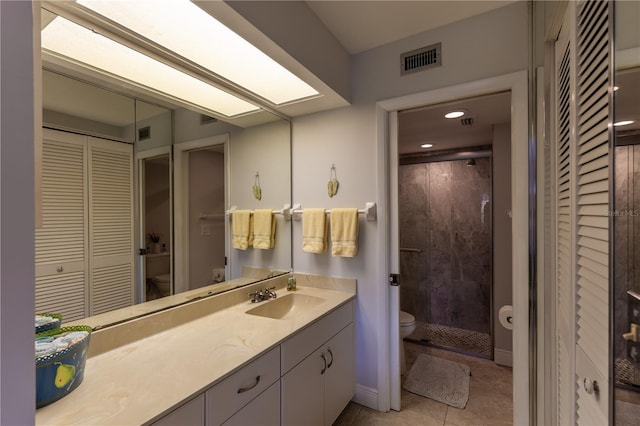 bathroom featuring vanity, a stall shower, a closet, tile patterned floors, and toilet