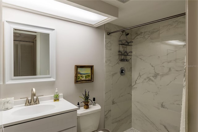 full bath featuring a tile shower, toilet, and vanity