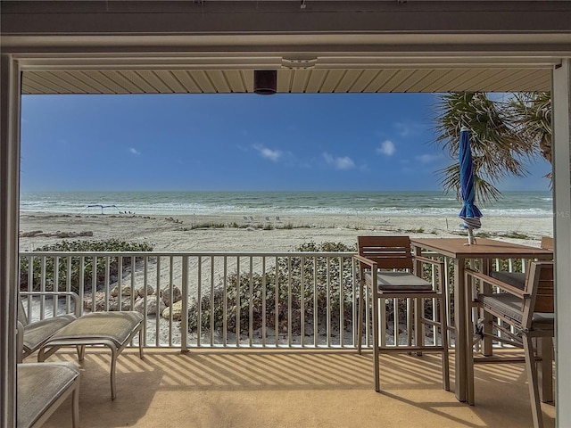 balcony featuring a water view and a beach view