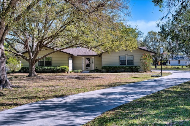 single story home with driveway and a front lawn