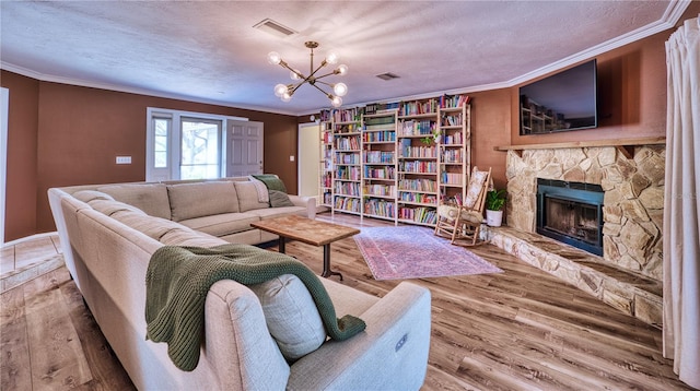 living room with ornamental molding, a stone fireplace, and wood finished floors