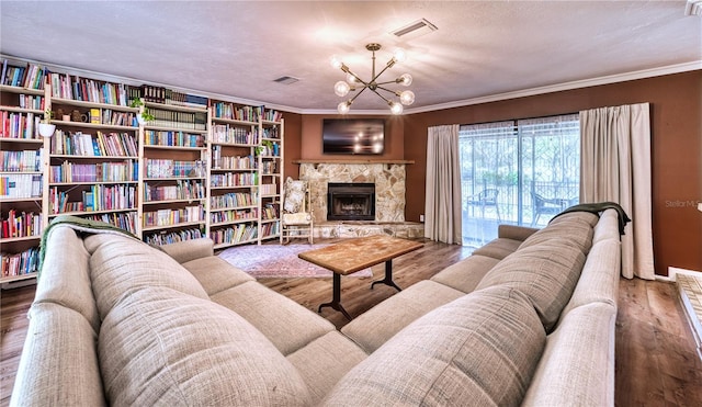 living area with ornamental molding, a fireplace, wood finished floors, and visible vents