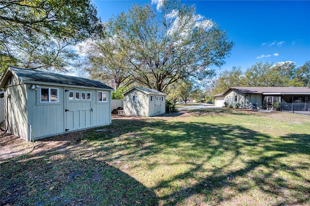 view of yard with a storage unit, an outdoor structure, and fence