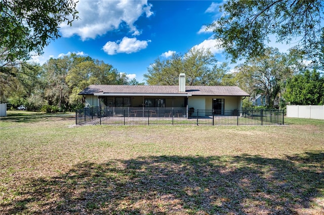 back of property featuring a lawn, a chimney, and fence