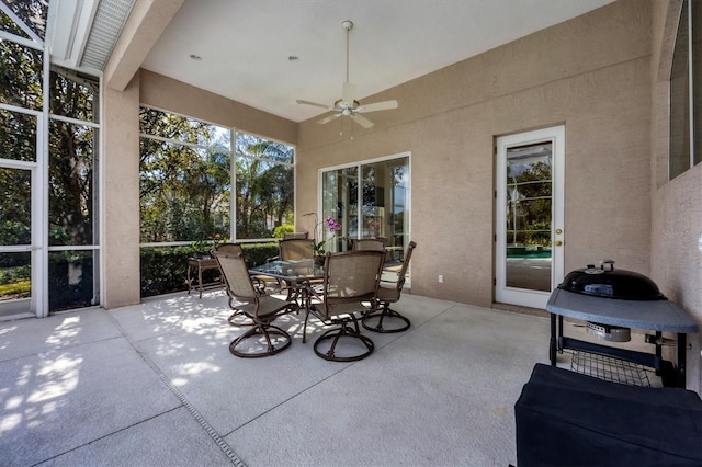 view of patio / terrace with glass enclosure, ceiling fan, and outdoor dining space